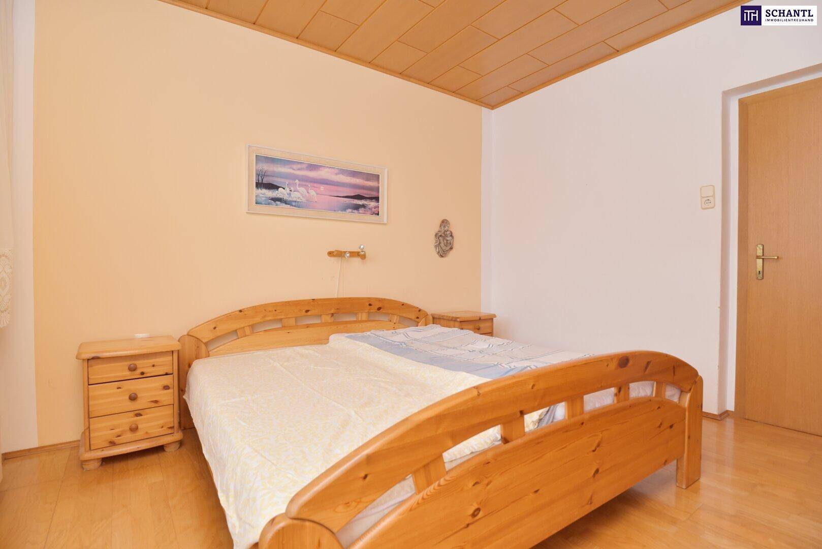 Schlafzimmer mit Holzbett, Nachttischen und Blick zur Zimmertür.