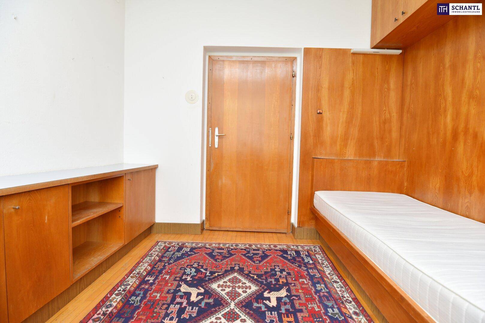 Kinderzimmer oder Büro mit Holzbett und Einbauschränken, Blick zur Tür.