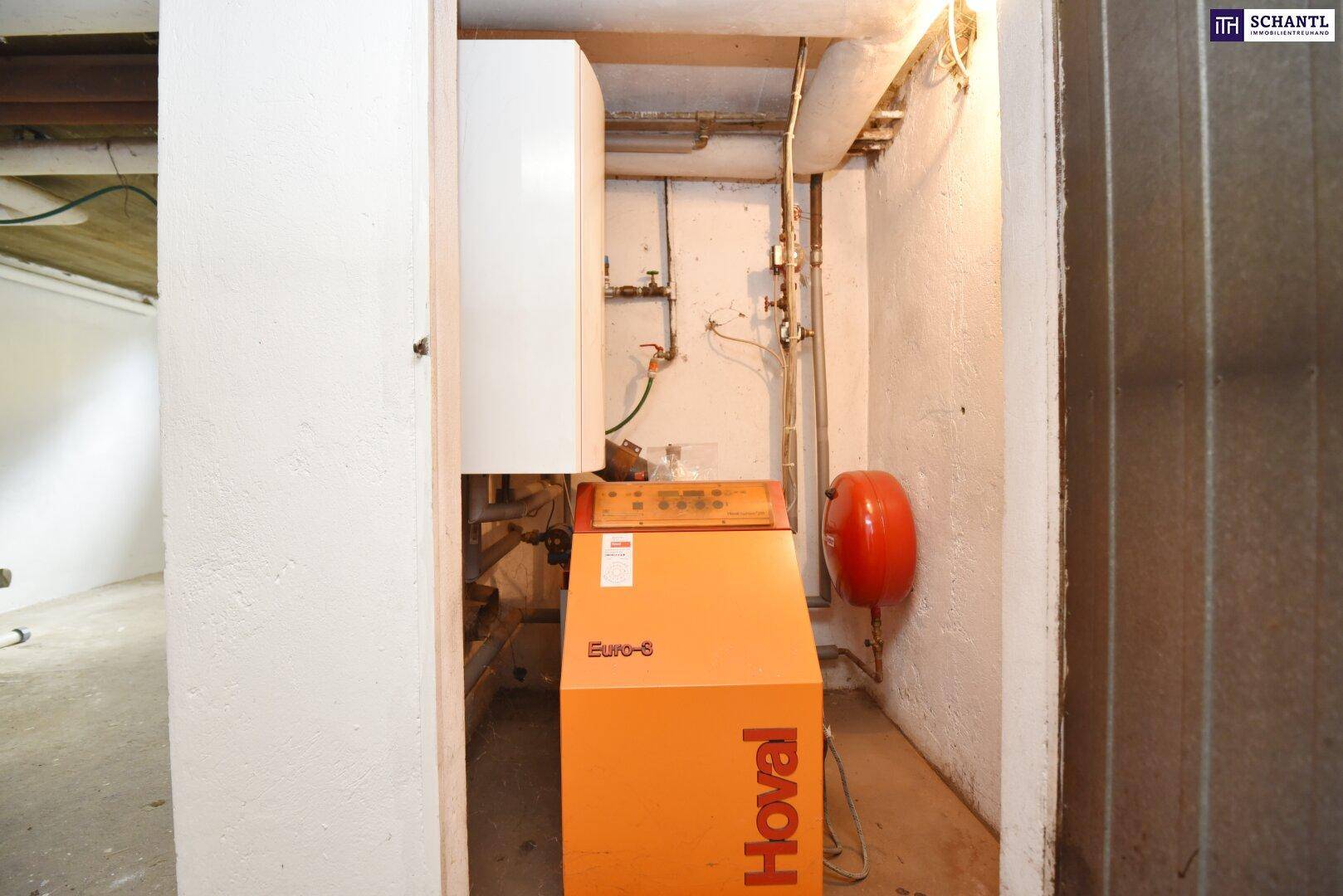 Heizraum im Keller mit Heizungsanlage und Warmwasserspeicher.