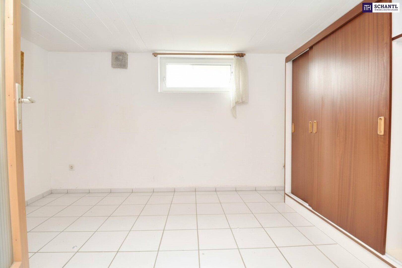 Ausgebauter Kellerraum mit weißen Fliesen und Einbauschrank.