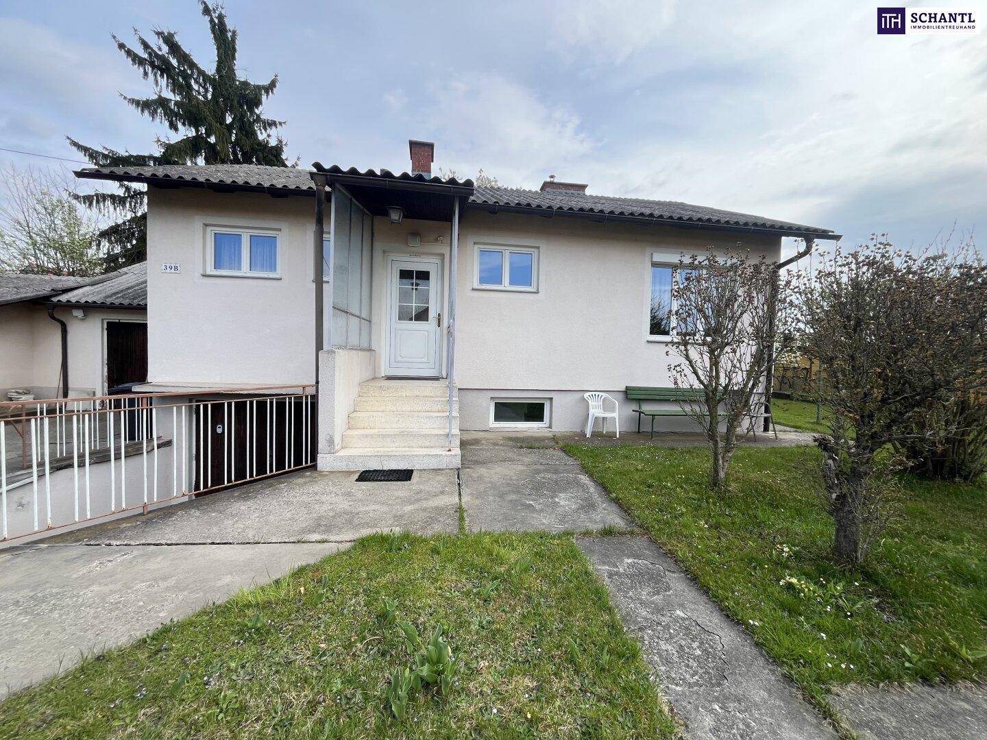 Vorderansicht des Hauses mit Eingangsbereich, Treppe und Zufahrt.