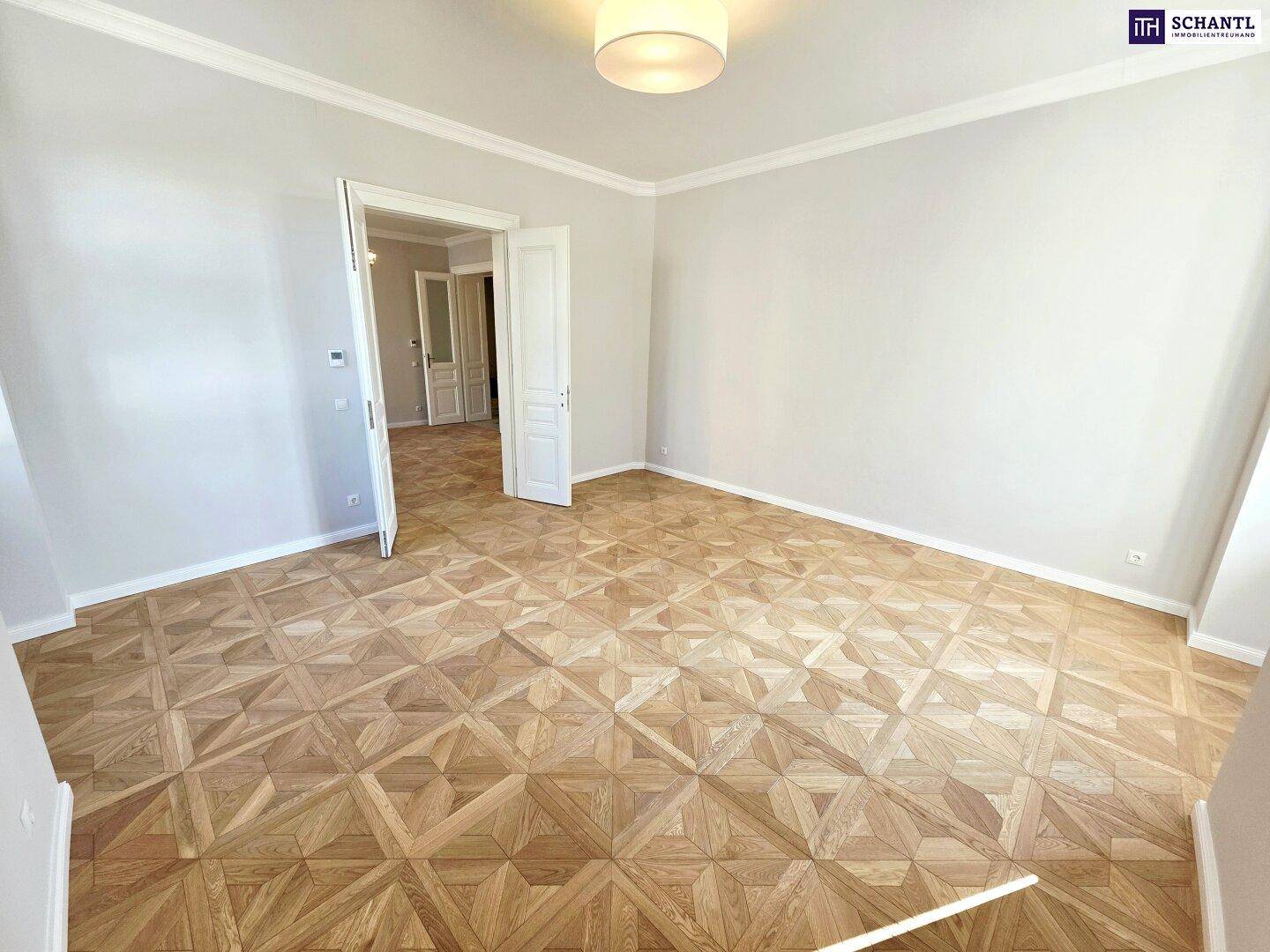 Heller Raum mit klassischem Parkettboden und schlichter Deckenleuchte, ideal für Wohnzwecke.