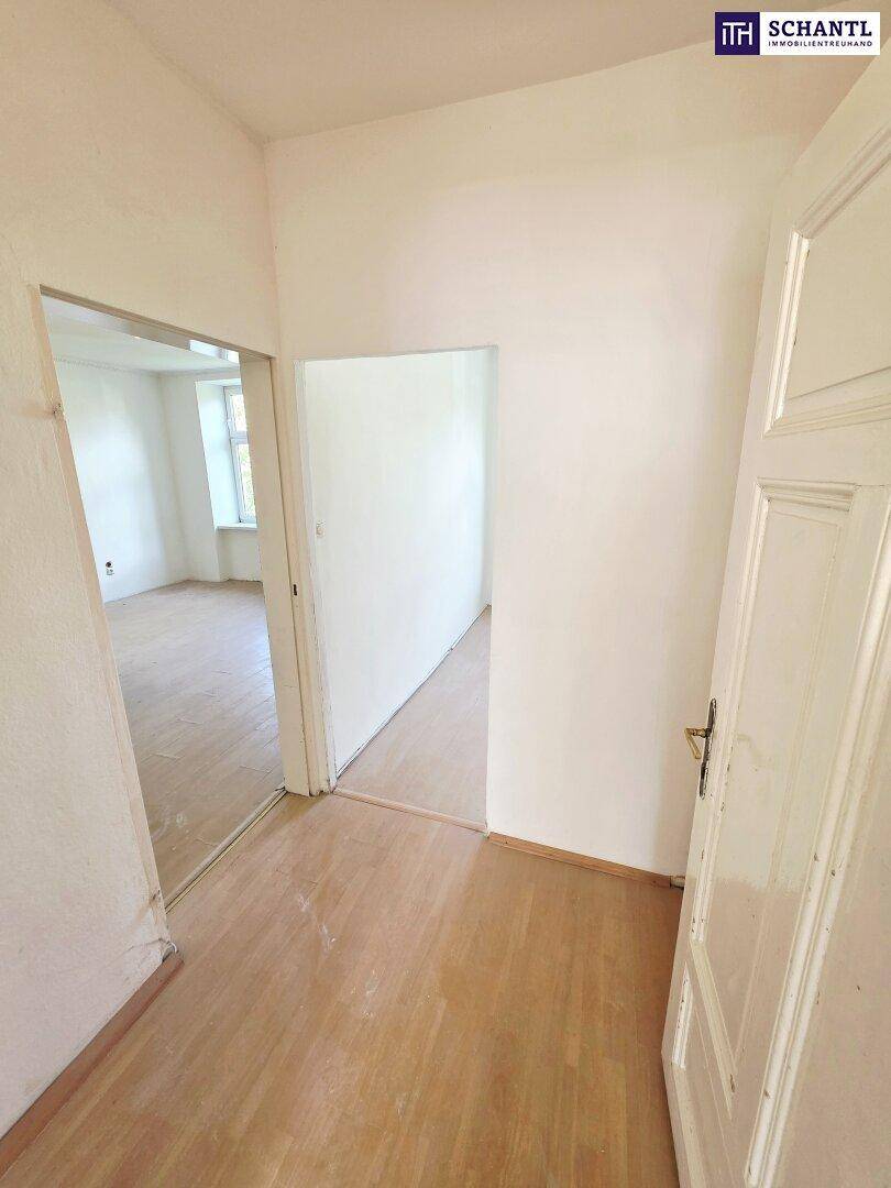 Heller Flur mit Holzboden, der zu weiteren Räumen führt und viel Potenzial bietet.