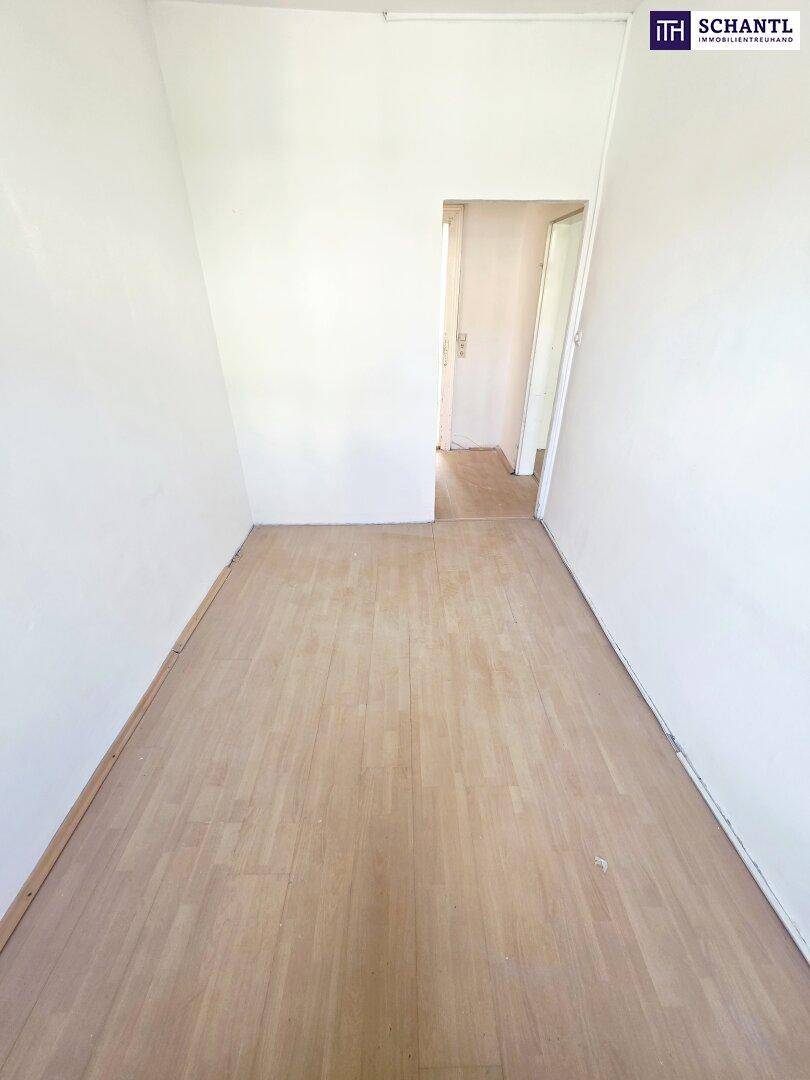 Langer, schmaler Raum mit Holzboden und weiß gestrichenen Wänden, ideal für ein Büro.