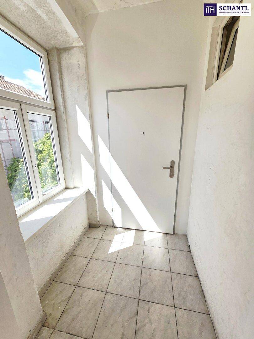 Heller Eingangsbereich mit Fliesenboden und Fenster, das natürliches Licht spendet.