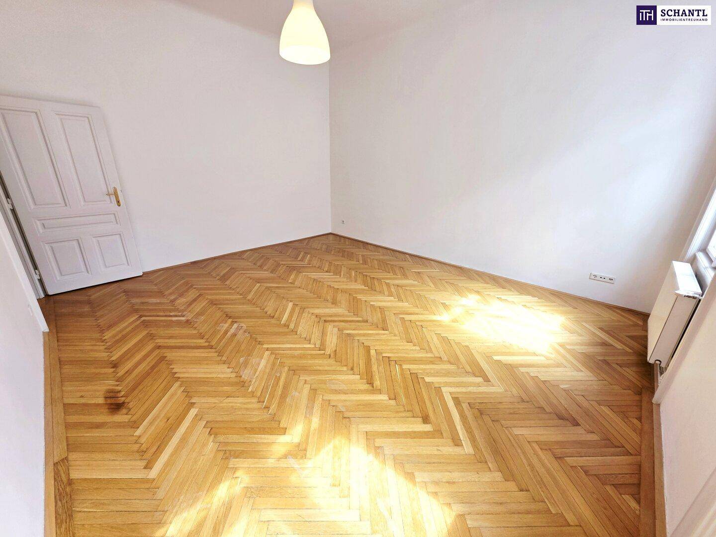 Lichtdurchfluteter Raum mit Fischgrätparkett und weiß gestrichenen Wänden, ideal für individuelle Einrichtung.