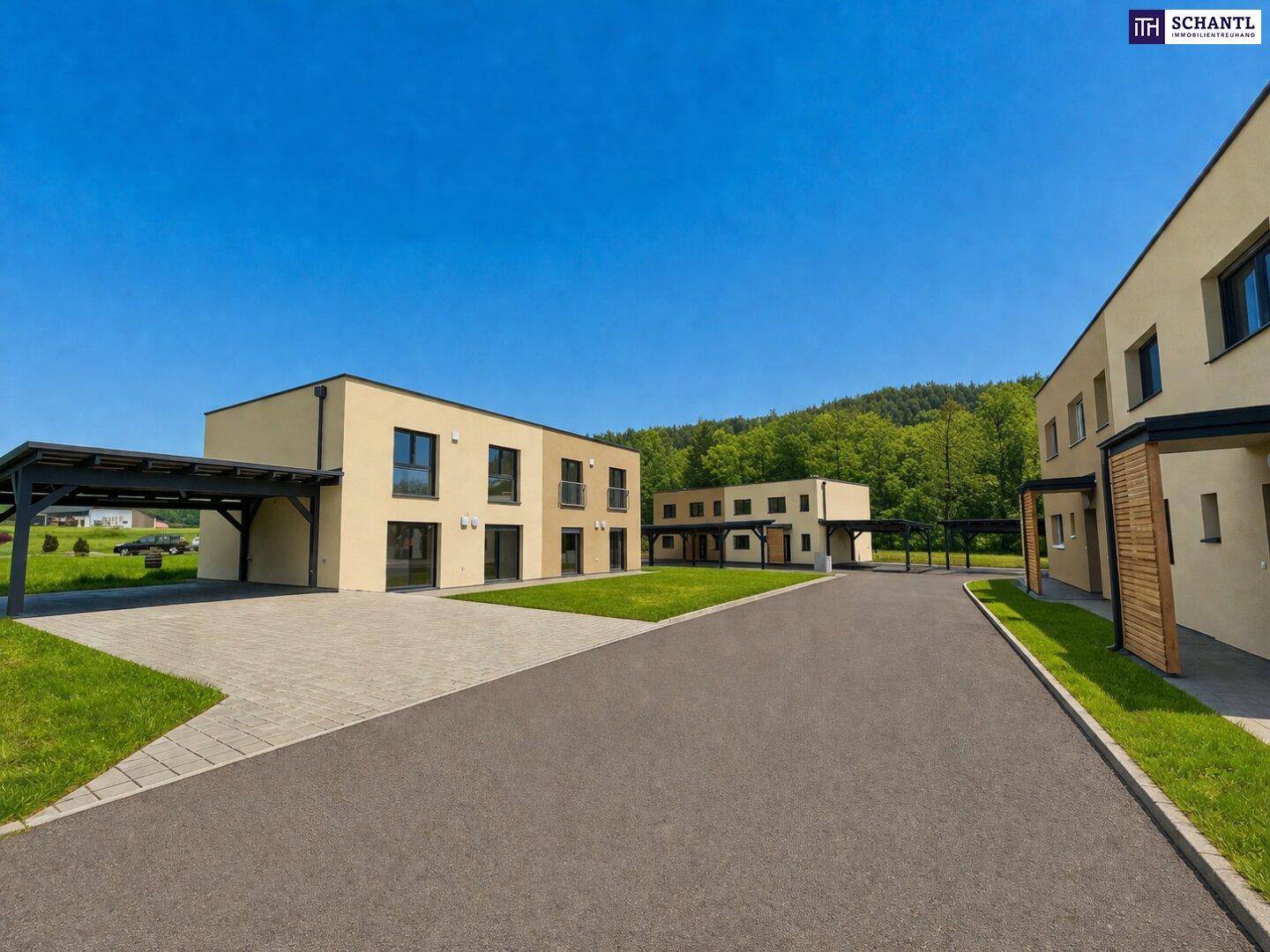 Gesamtansicht einer Siedlung mit modernen Reihenhäusern, Carports und gepflegten Außenanlagen.