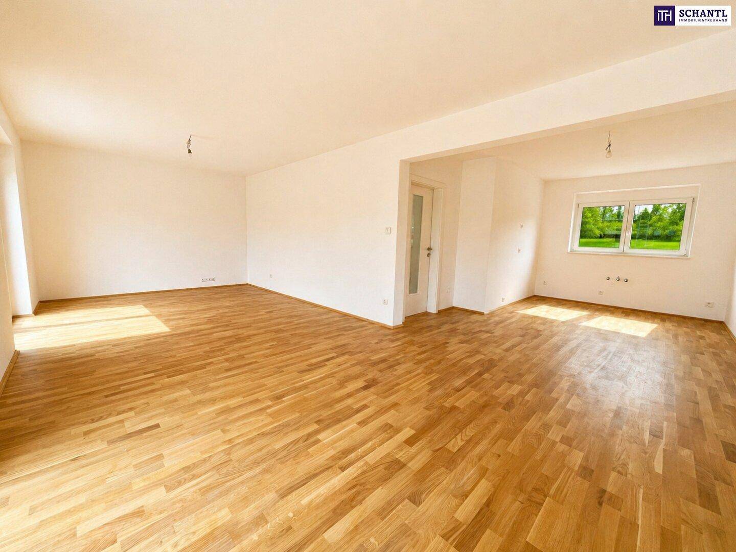 Weitläufiges Wohnzimmer mit Eichenparkett und großen Fenstern, die viel Tageslicht hereinlassen.