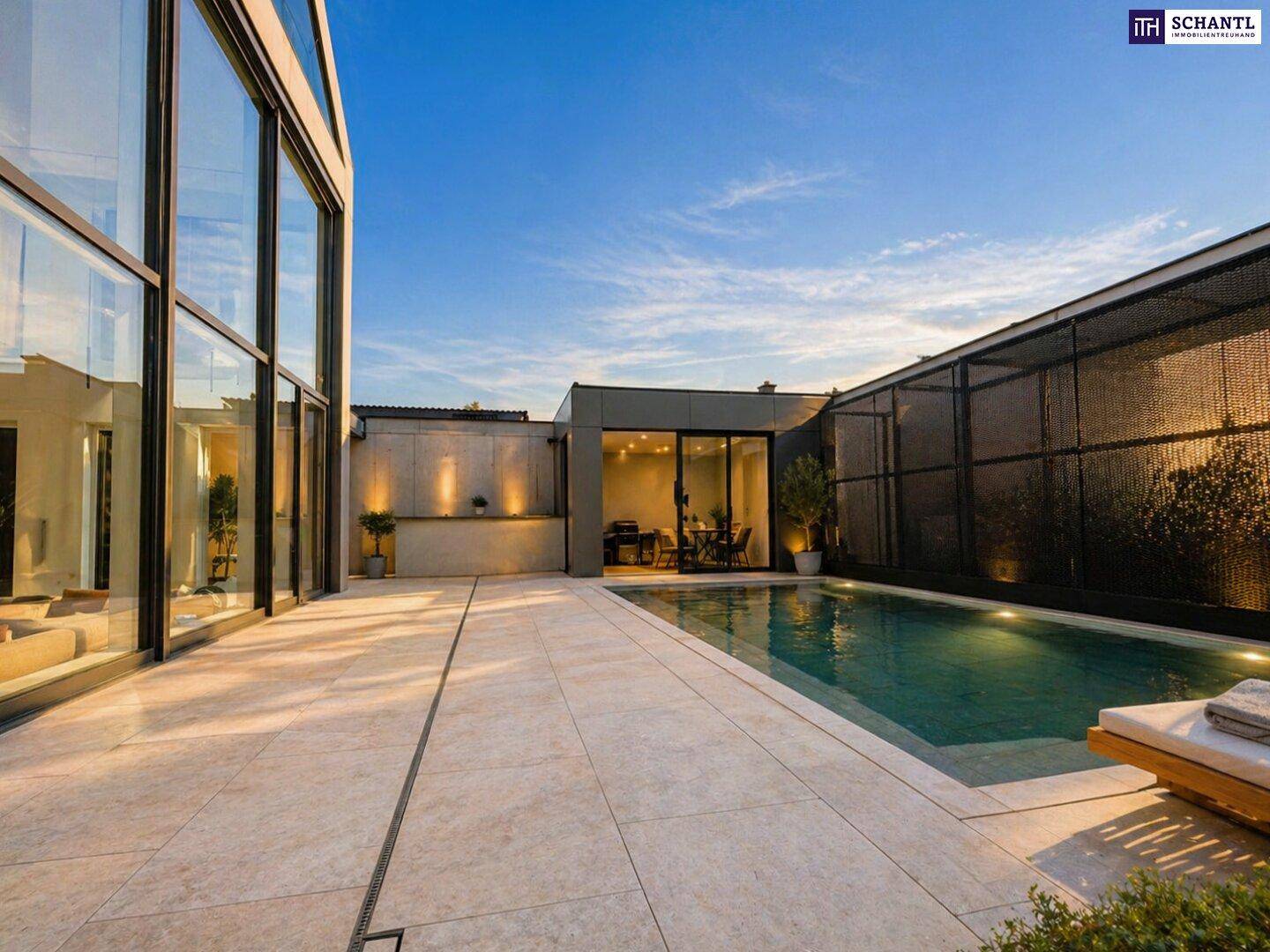 Abendliche Ansicht des Pools mit beleuchteter Terrasse und moderner Architektur.