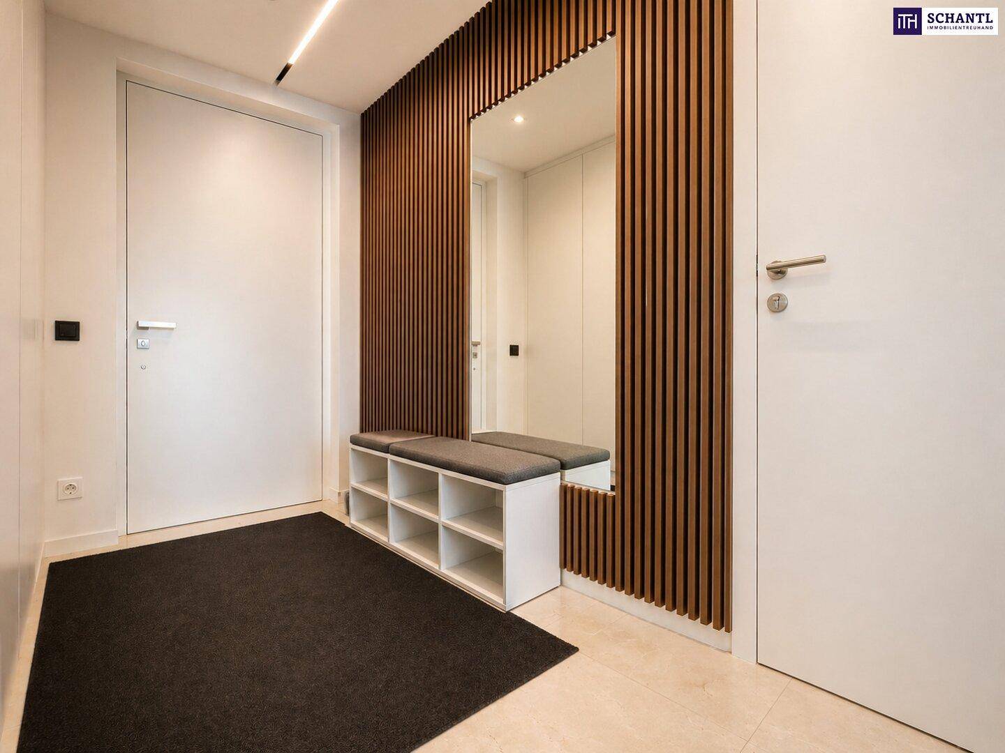 Moderner Eingangsbereich mit Holzlamellenwand, Spiegel und integrierter Sitzbank.