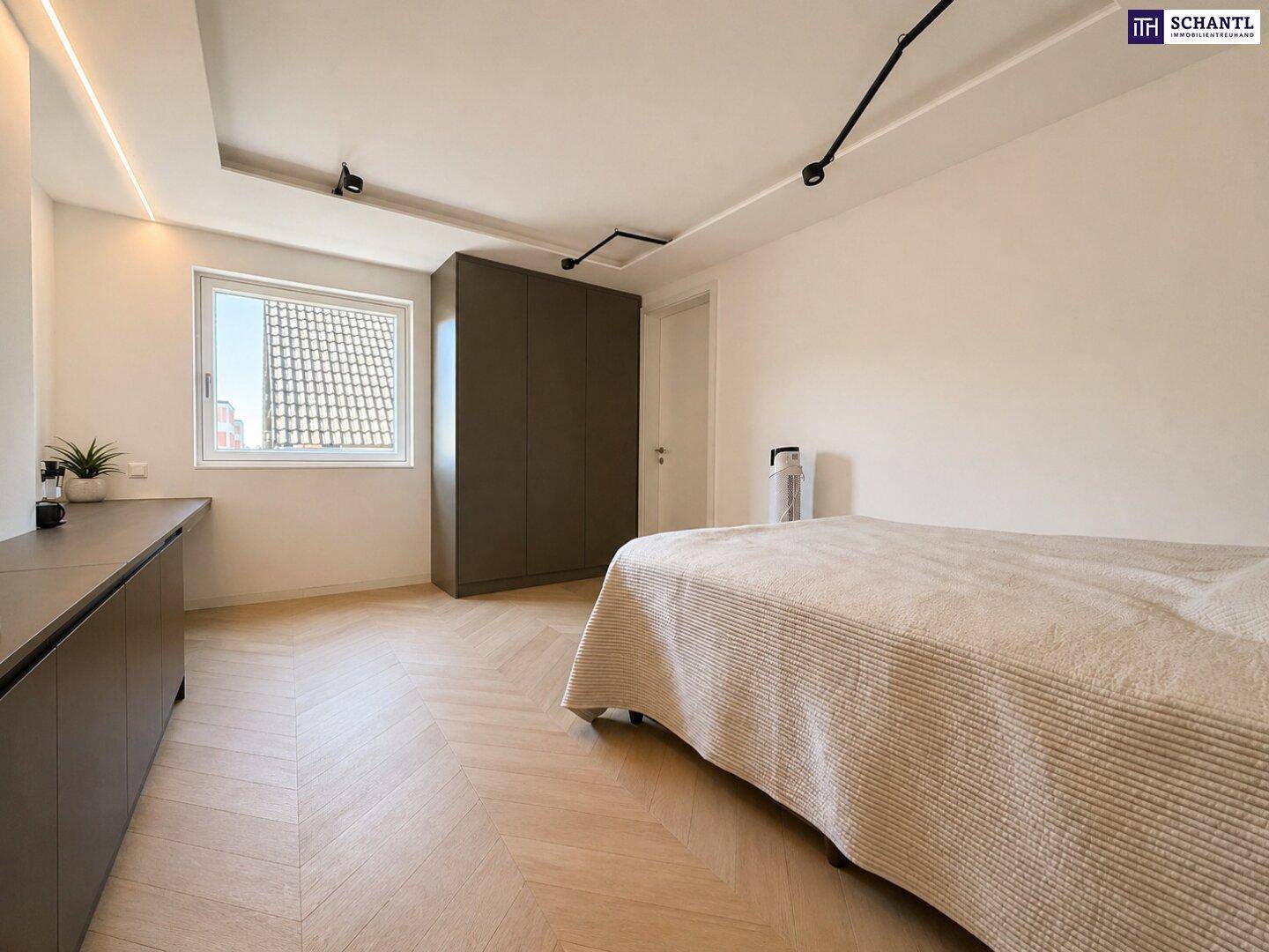 Helles Schlafzimmer mit Parkettboden, Einbauschrank und indirekter Deckenbeleuchtung.