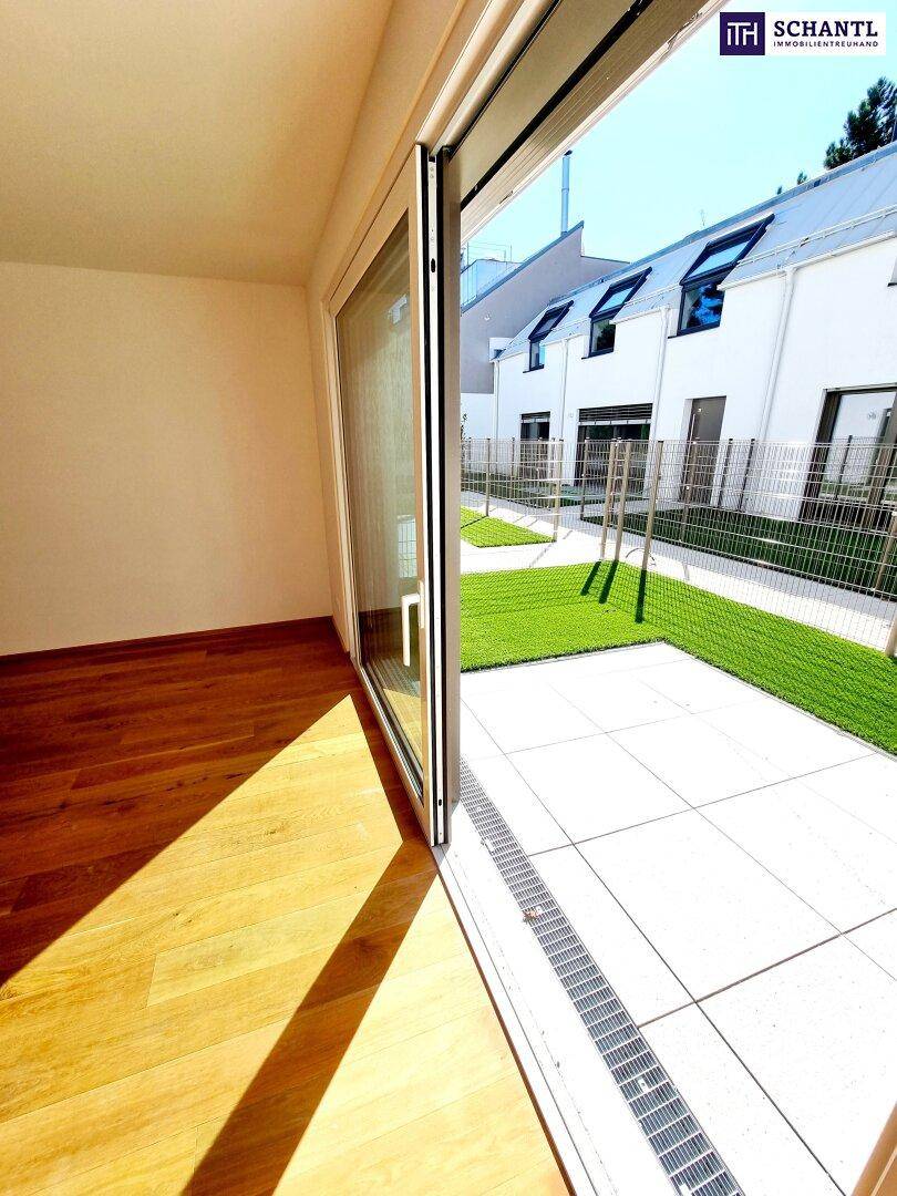 Heller Wohnraum mit Schiebetür, die zu einer privaten Terrasse führt.