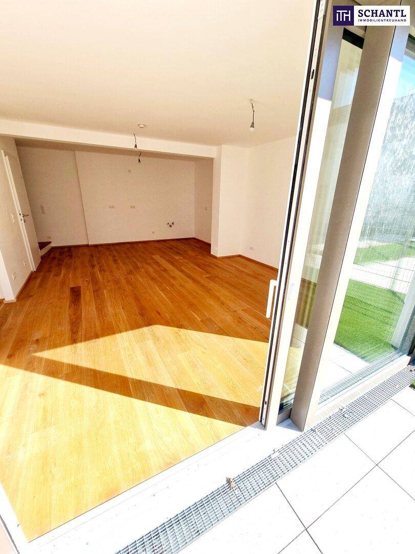 Lichtdurchfluteter Wohnraum mit Holzboden und direktem Zugang zur Terrasse.