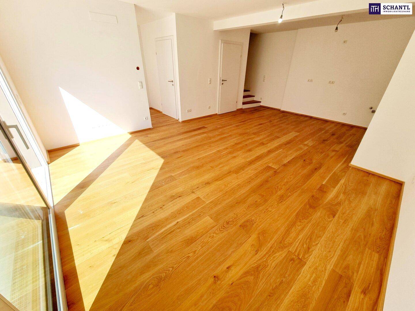 Geräumiger Wohnbereich mit Holzboden und viel Tageslicht, bereit zur Einrichtung.