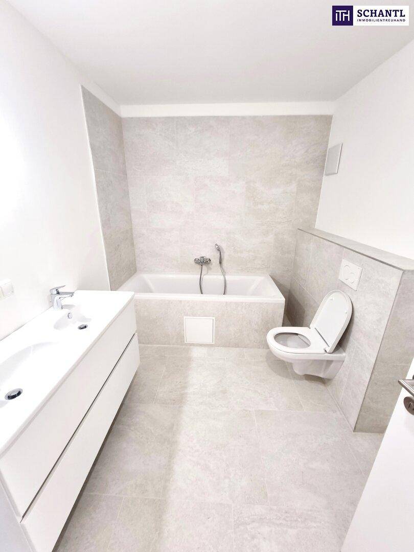 Helles Badezimmer mit Badewanne, wandhängender Toilette und modernem Design.