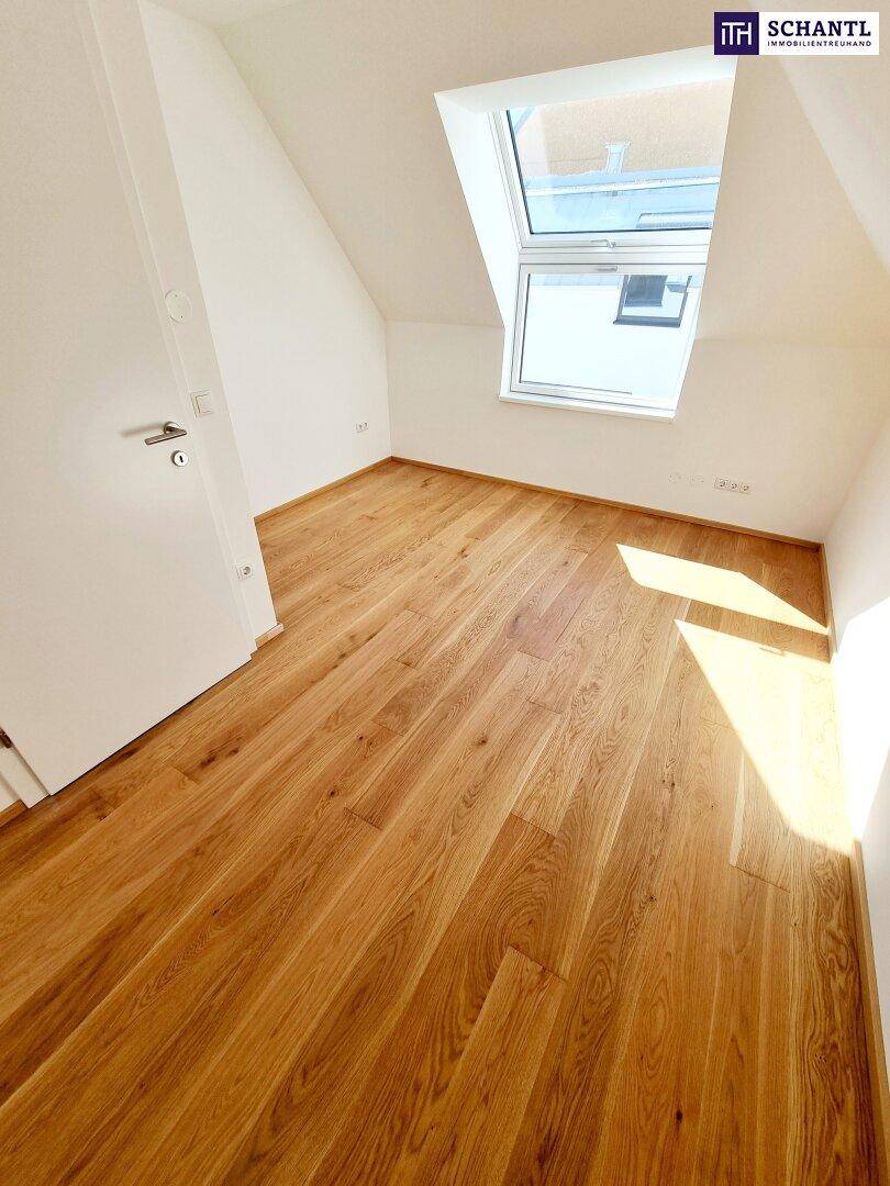 Helles Schlafzimmer im Dachgeschoss mit Holzboden und schrägen Wänden.