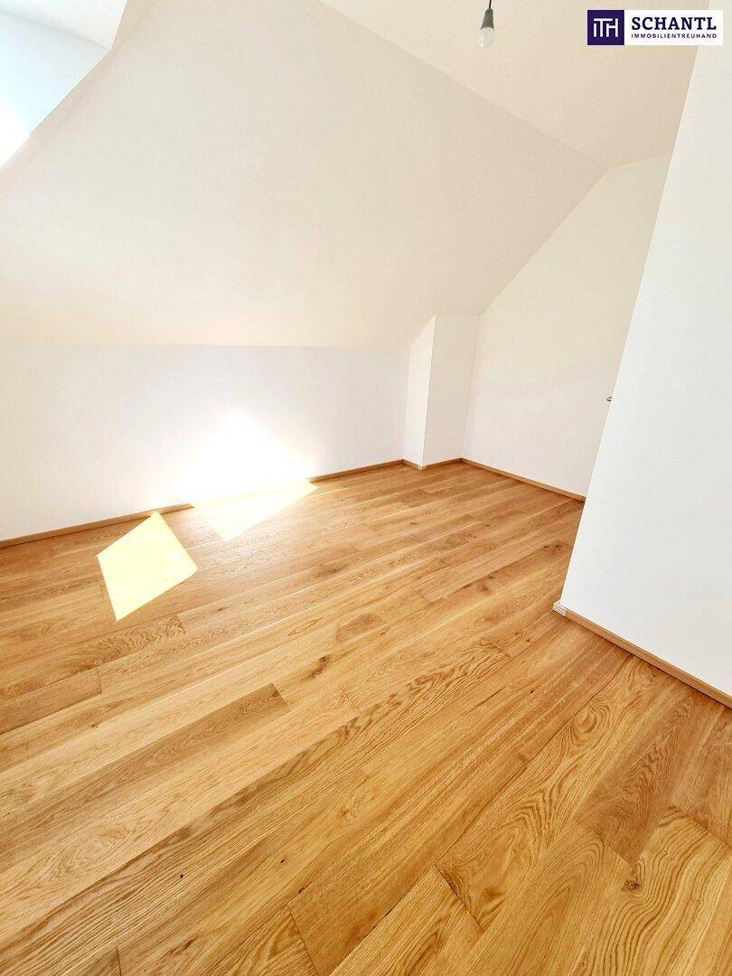 Geräumiges Dachgeschosszimmer mit Holzboden und schrägen Decken.