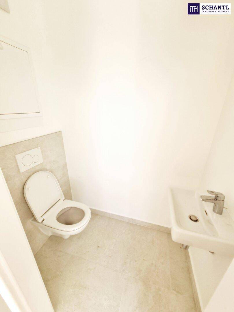 Kleines Gäste-WC mit wandhängender Toilette und Handwaschbecken.