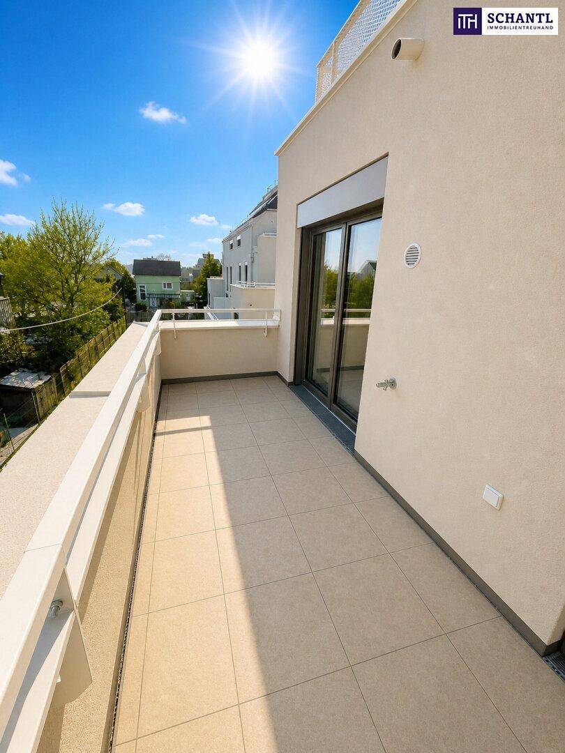Sonniger Balkon mit Fliesenboden und Blick auf die umliegenden Häuser und grüne Landschaft.