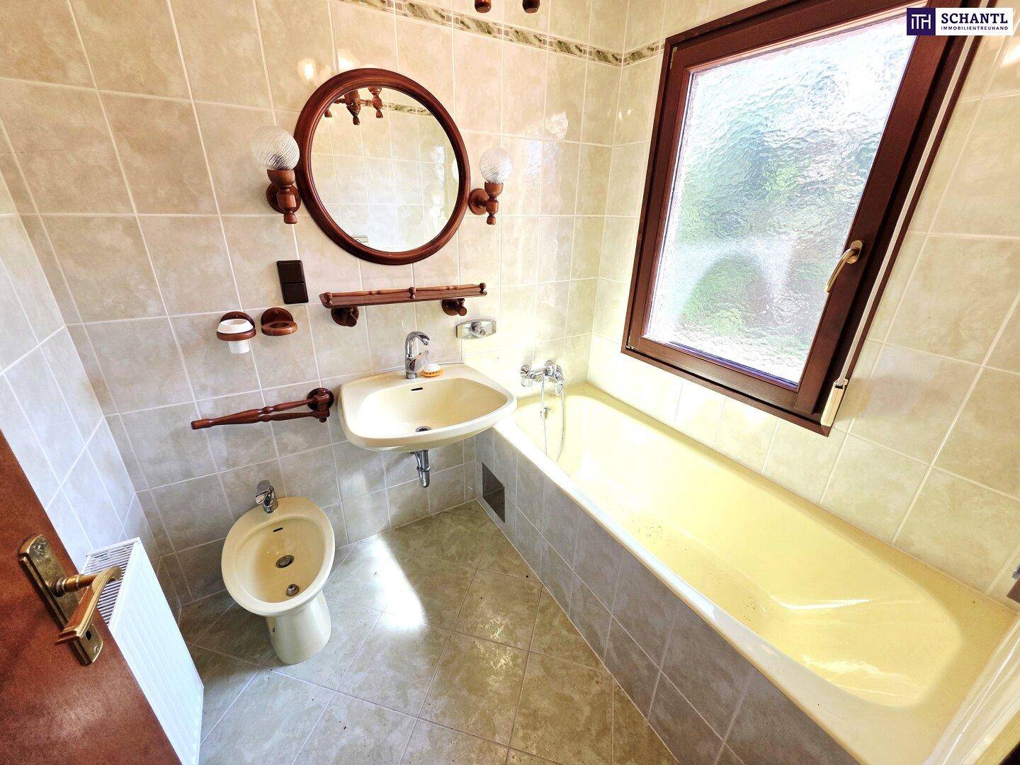 Badezimmer mit Badewanne, Waschbecken, Bidet und Fenster.
