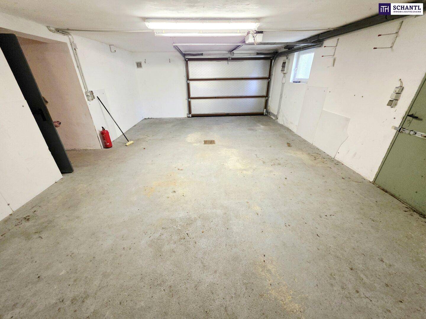 Weitere Ansicht der Garage mit Betonboden und Rolltor, bereit zur Nutzung.