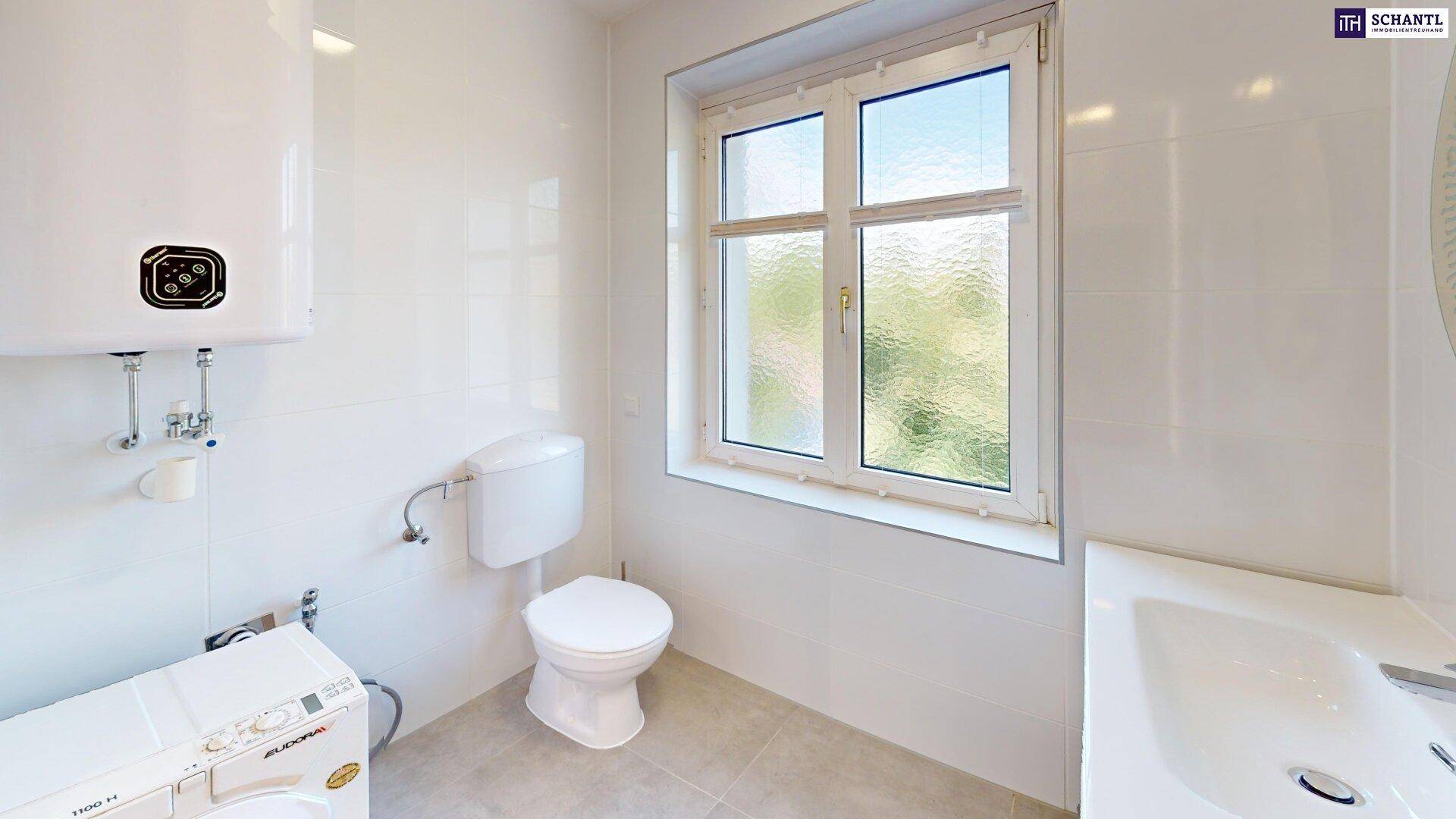 Funktionales Badezimmer mit WC, Waschmaschine, Warmwasserboiler und Fenster.