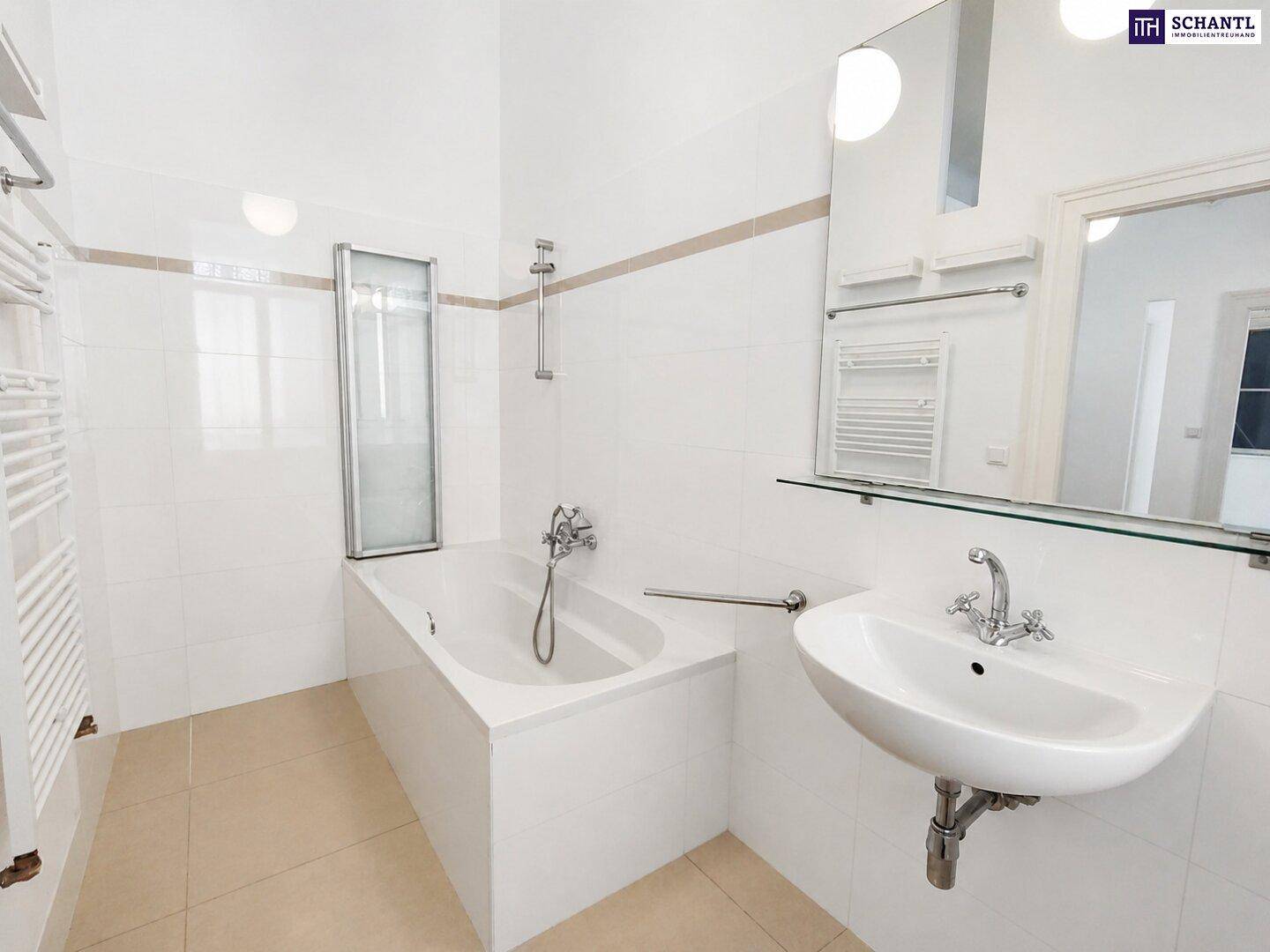 Helles Badezimmer mit Badewanne, Duschabtrennung, Einzelwaschbecken und beheiztem Handtuchhalter.