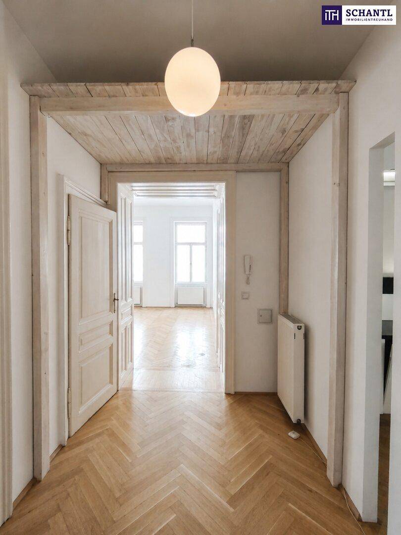 Eingangsbereich mit Fischgrätparkett, Holzdecke und offenem Durchgang zu den Wohnräumen.