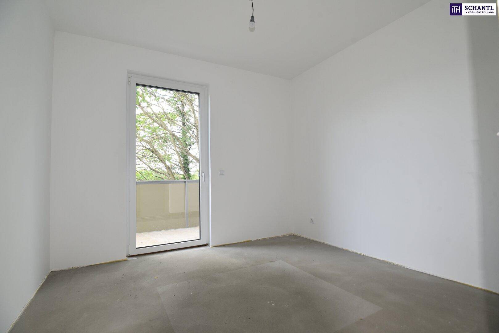 Heller Raum mit Zugang zu einem Balkon, weißen Wänden und Betonboden.