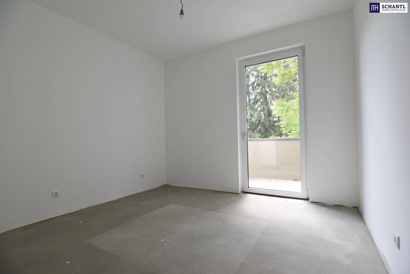 Heller Raum mit Zugang zu einem Balkon, weißen Wänden und Betonboden.