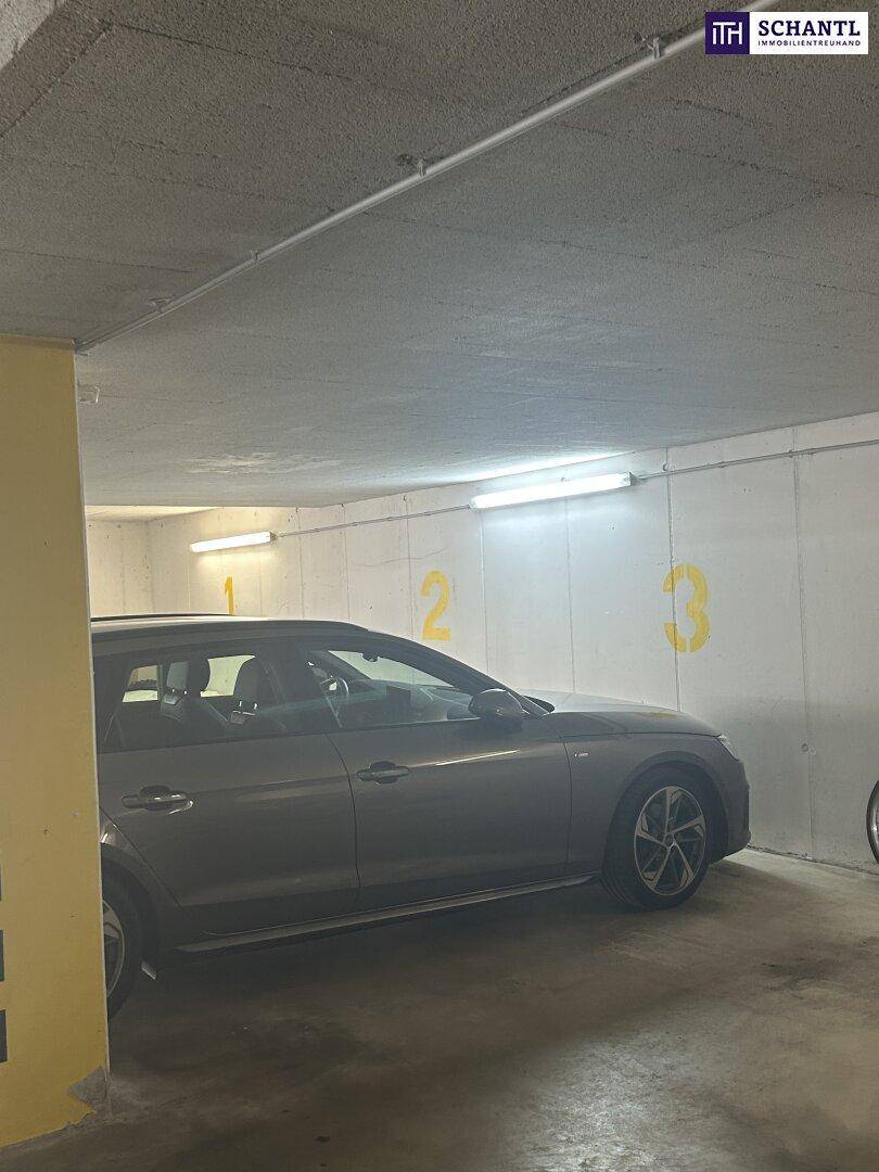 Parkplatz in einer Tiefgarage mit nummerierten Stellplätzen und einem geparkten Auto.