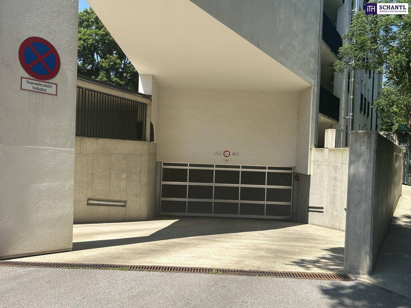 Geschlossenes Garagentor der Tiefgarage mit Betonwänden und einem Halteverbotsschild.