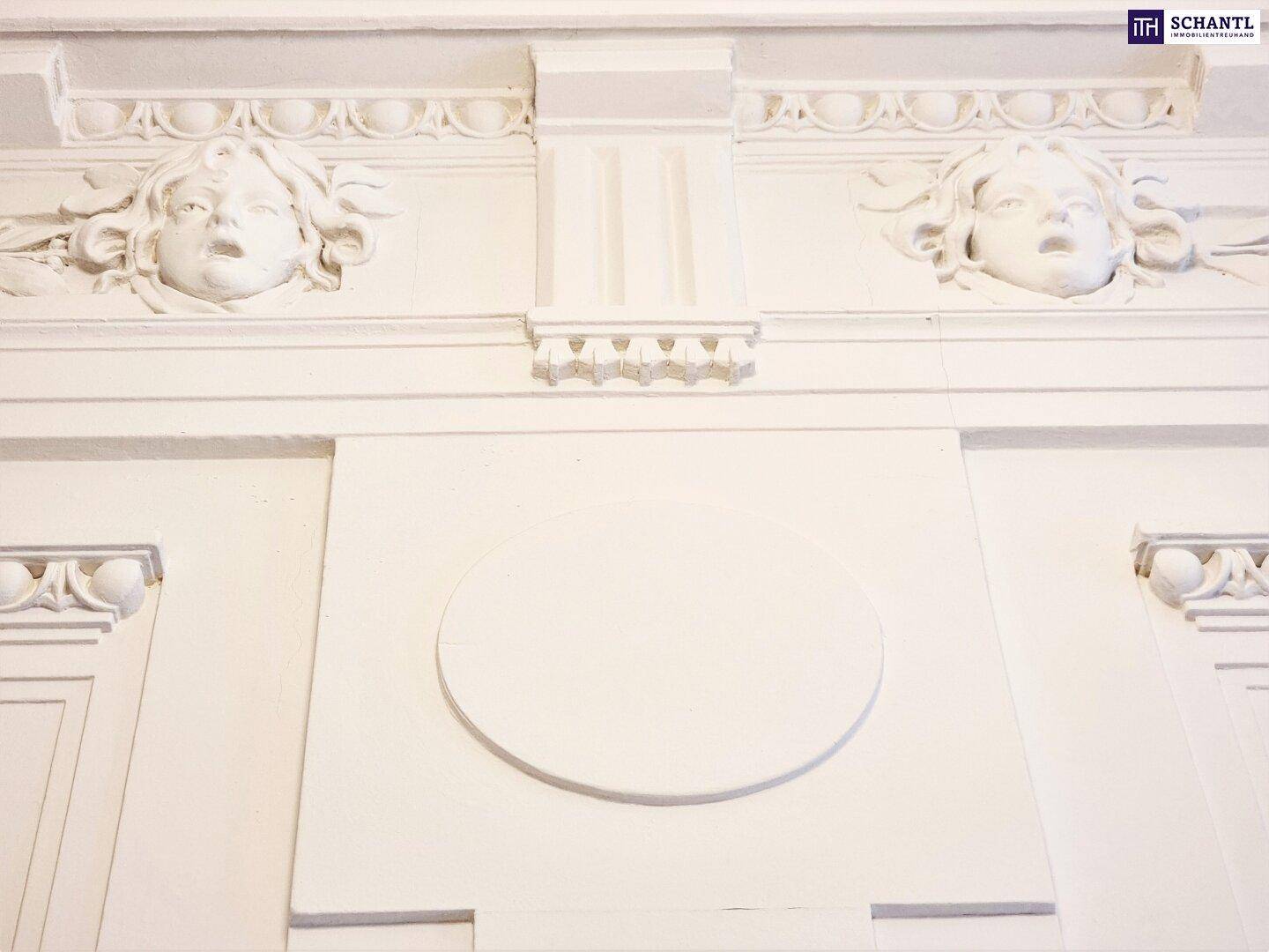 Detailaufnahme von kunstvollen Stuckverzierungen an der Wand mit klassischen Motiven.