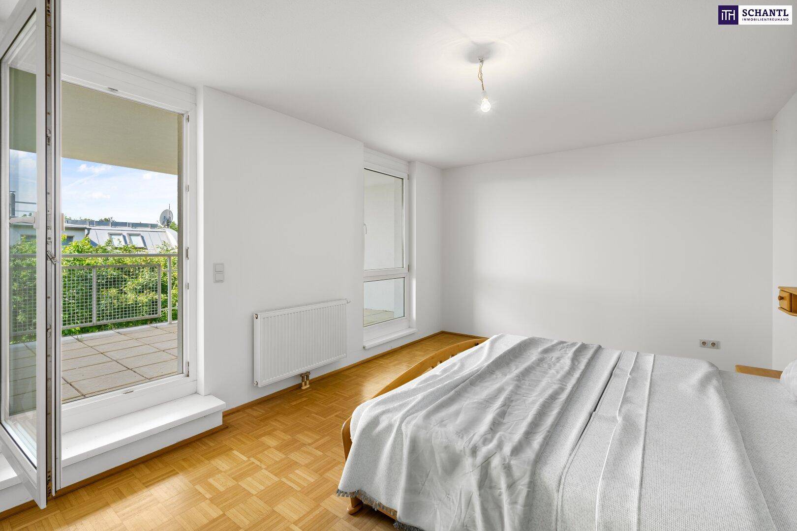Unmöbliertes Schlafzimmer mit Parkettboden, weißen Wänden und großem Balkonzugang.