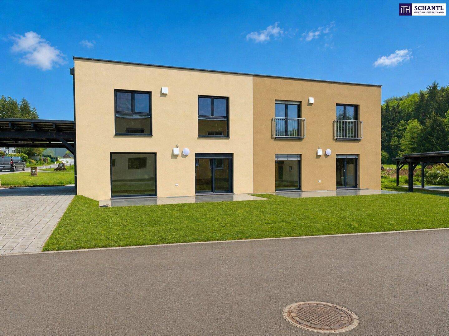 Moderne Doppelhaushälfte mit heller Fassade, großen Fenstern und gepflegtem Vorgarten.