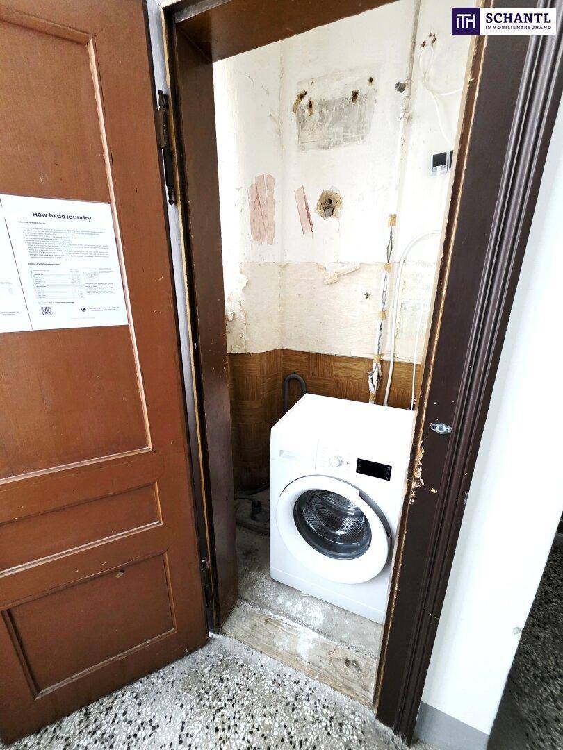 Kleiner Abstellraum mit Waschmaschine und sichtbaren Installationen, bereit zur Renovierung.