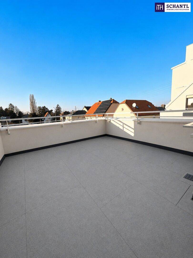 Geräumige, geflieste Terrasse mit weißem Geländer und weitem Blick auf die Nachbarschaft.