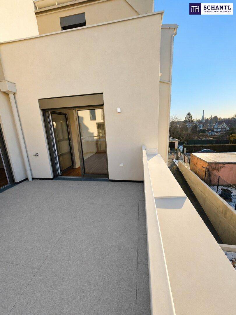 Helle Terrasse mit Fliesenboden und direktem Zugang zu den Innenräumen durch eine große Schiebetür.