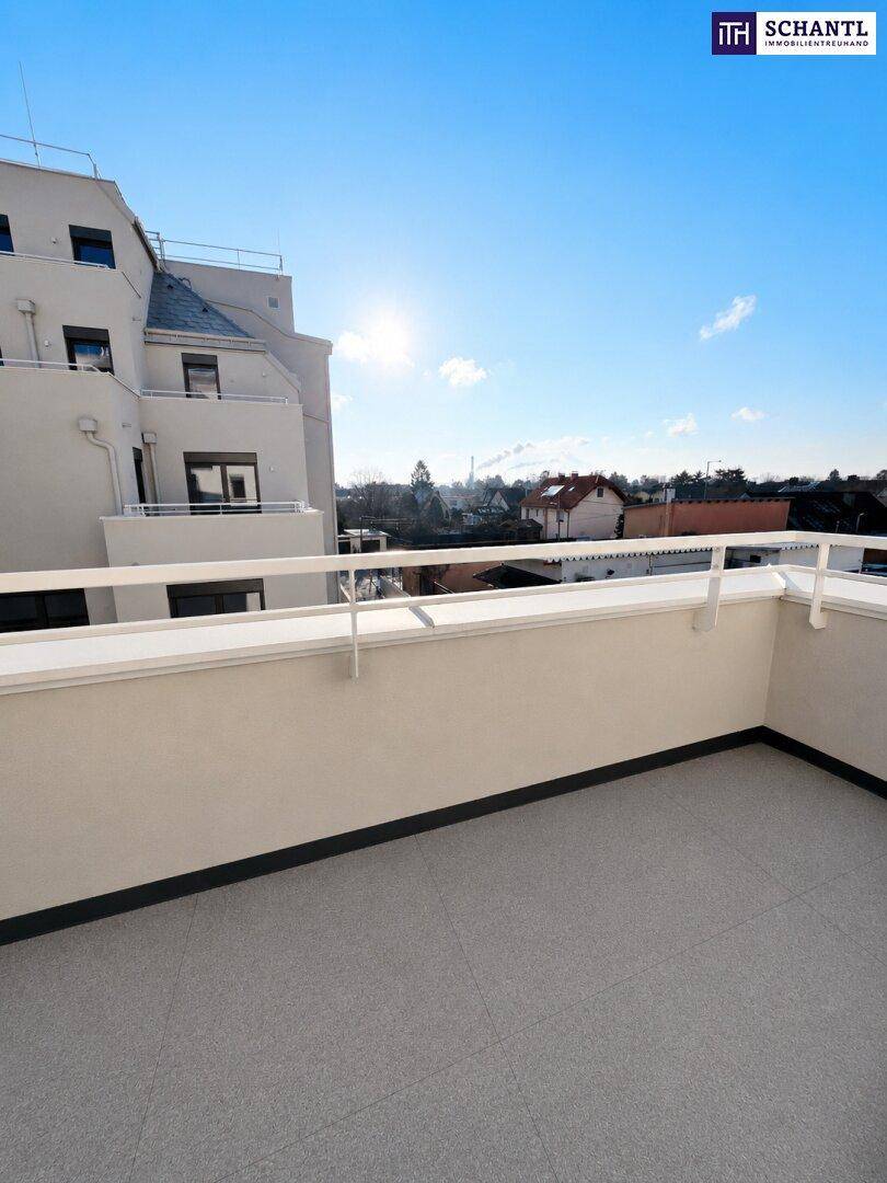 Heller Balkon mit modernen Fliesen und weißem Geländer unter blauem Himmel.
