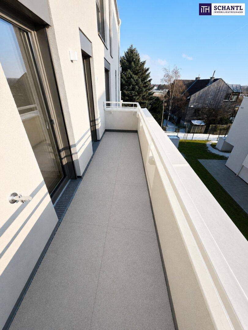 Langer Balkon mit Fliesenboden und weißem Geländer, ideal für entspannte Stunden im Freien.