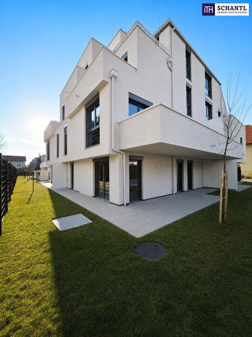 Architektonisch ansprechender Neubau mit sonnigem Garten und großzügiger Terrasse, ideal für Outdoor-Aktivitäten.