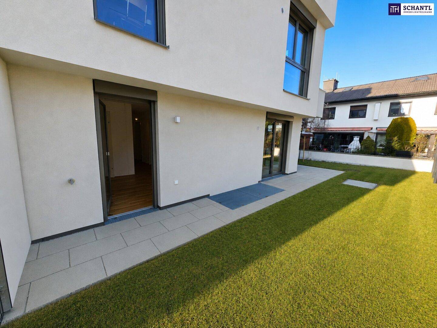 Heller Gartenbereich mit Terrasse und direktem Zugang zu einem Zimmer mit schönem Holzfußboden.