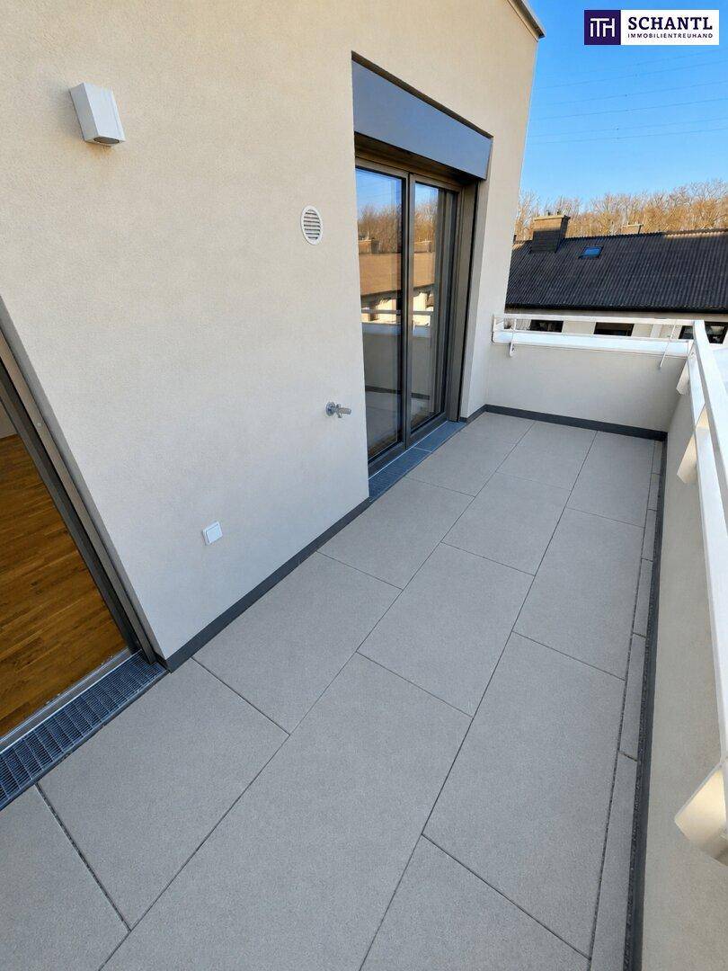 Sonniger Balkon mit Fliesenboden und Schiebetür, bietet Zugang zum Innenraum.