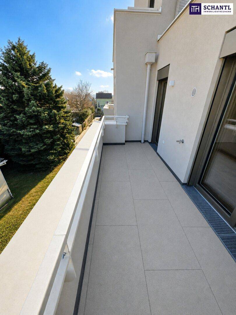 Geräumiger Balkon mit Fliesenboden und Blick auf die grüne Umgebung.