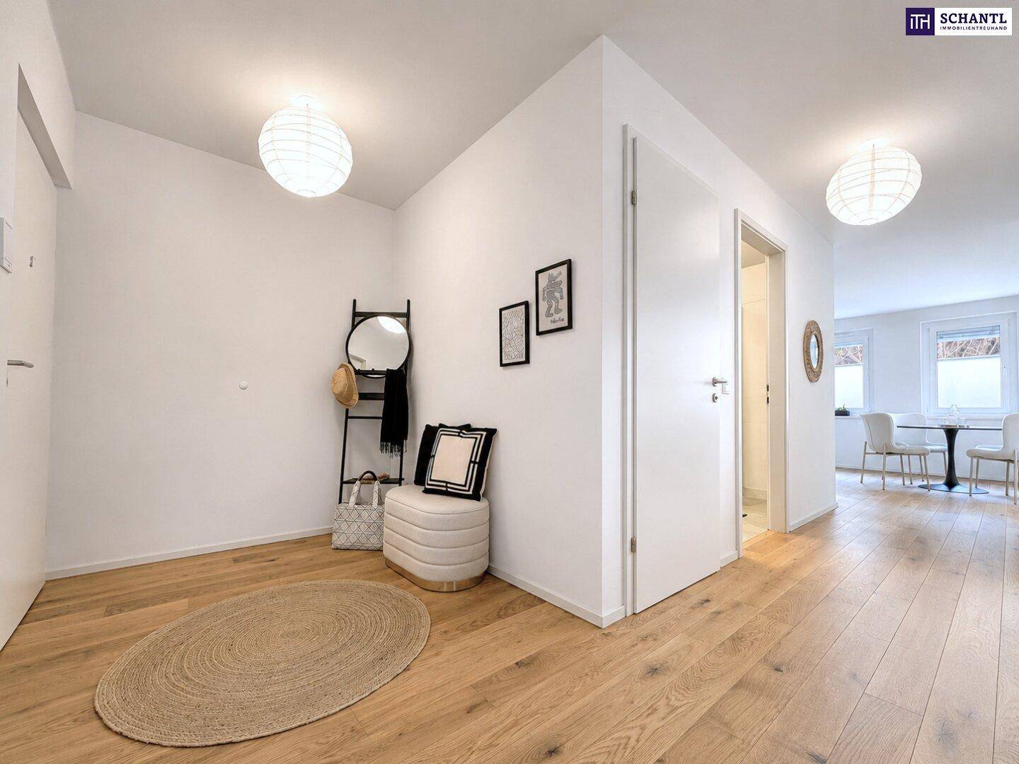 Heller Flur mit Holzboden, Garderobe und Zugang zu den Wohnbereichen.