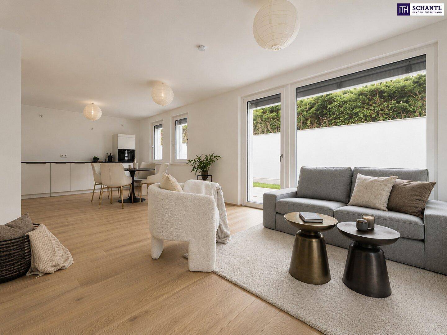 Offener Wohnbereich mit Sofa, Couchtischen und Blick auf die moderne Küche.