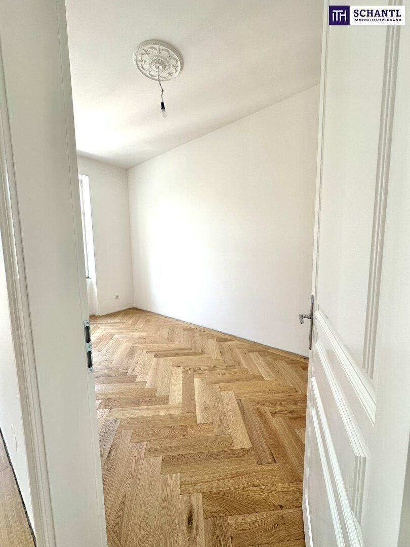 Frisch renoviertes Zimmer mit Fischgrätparkett und weiß gestrichenen Wänden, sehr hell und modern.