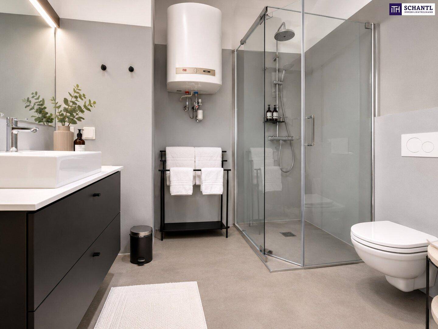 Modernes Badezimmer mit ebenerdiger Dusche, Waschtisch und Wand-WC in Grautönen.