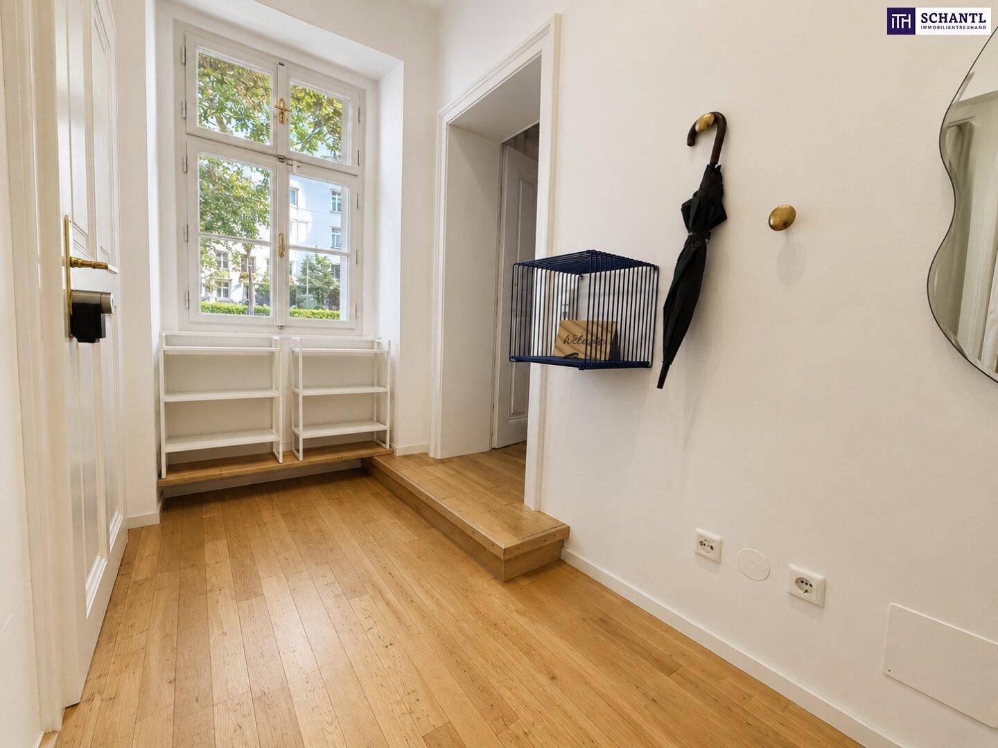 Heller Eingangsbereich mit Holzboden, Fenster und praktischen Ablagemöglichkeiten.