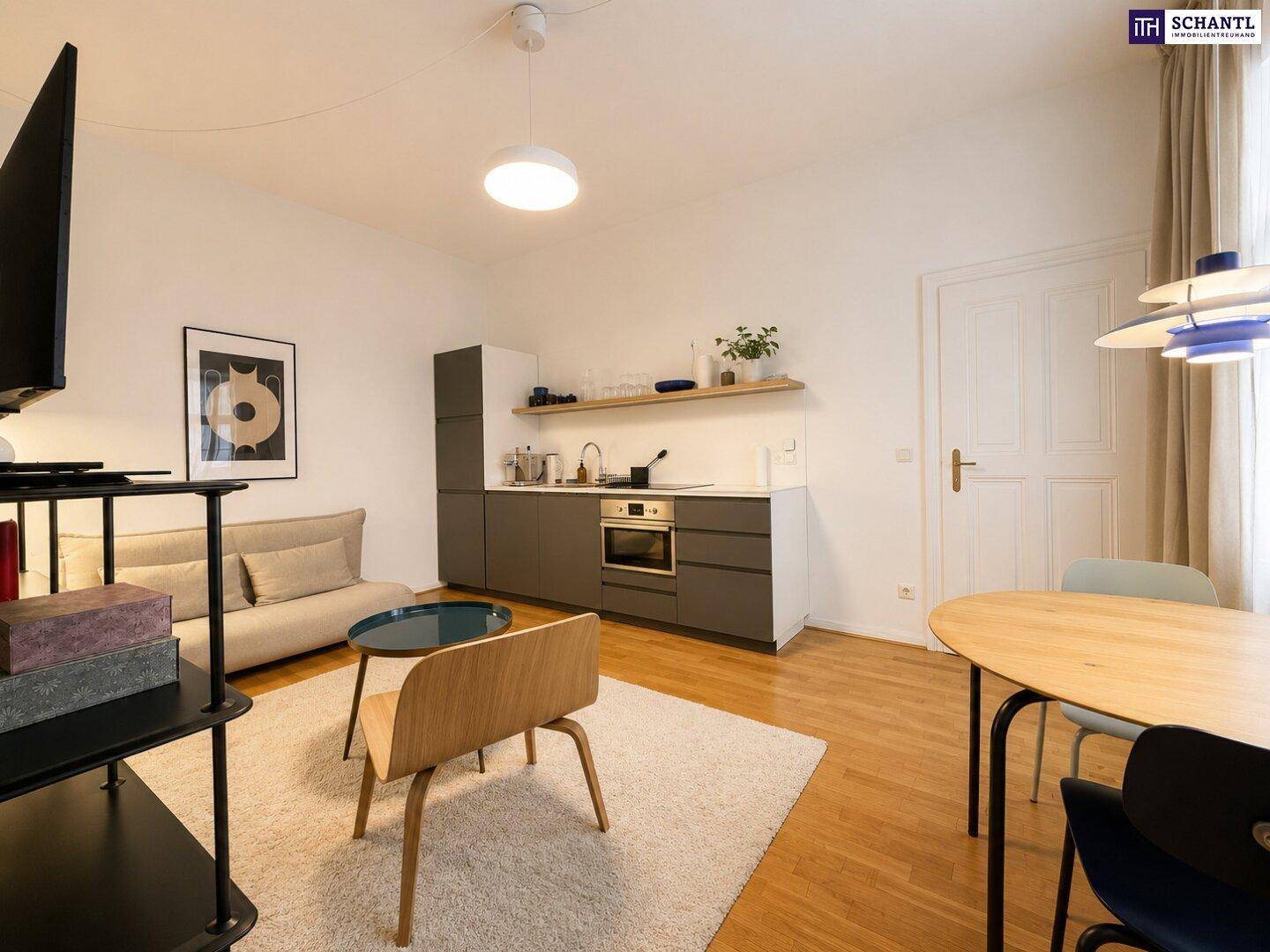 Gemütlicher Wohnbereich mit integrierter Küchenzeile, Sofa und Esstisch, ideal für Singles oder Paare.